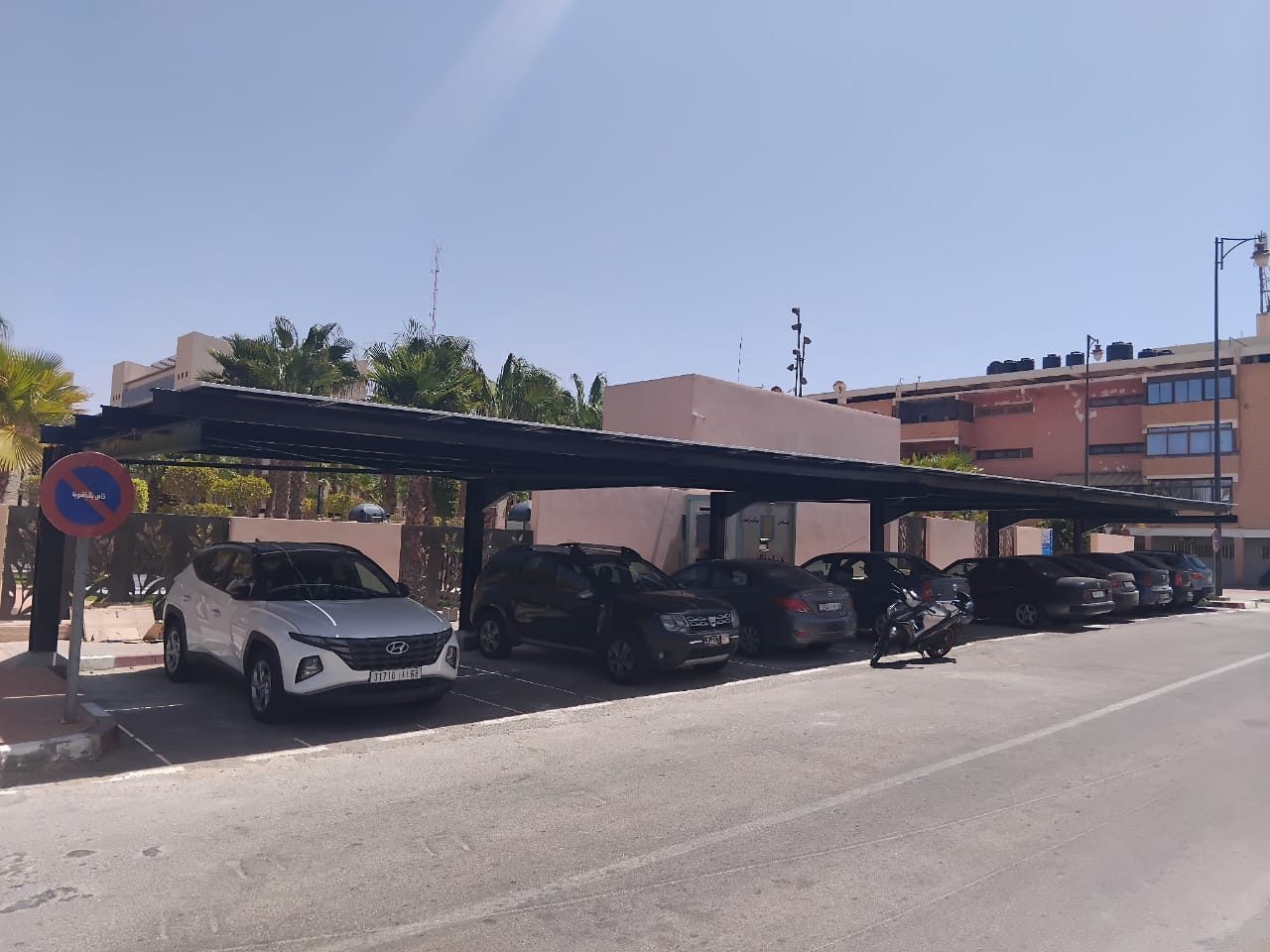 Ombrière photovoltaïque en console au-dessus d'un parking, véhicules stationnés dessous
